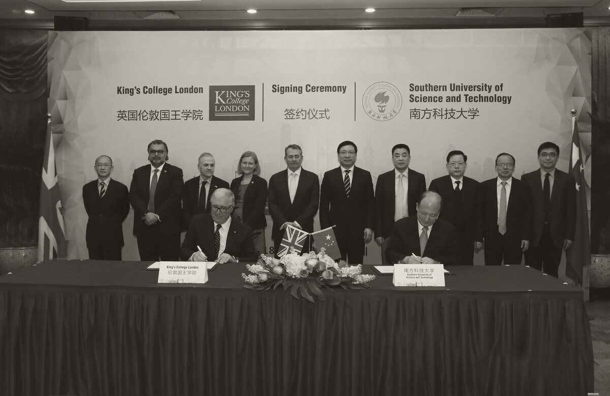Signing ceremony in Shenzhen, January 2018, between King's College London and the Southern University of Science and Technology, with UK and Chinese officials standing behind the signatories; Tayyeb Shah stands second from left